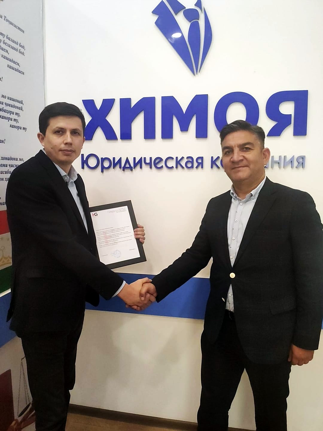 Navruz Odinaev与HAYAT集团分公司经理手持感谢信在Himoya办公室合影